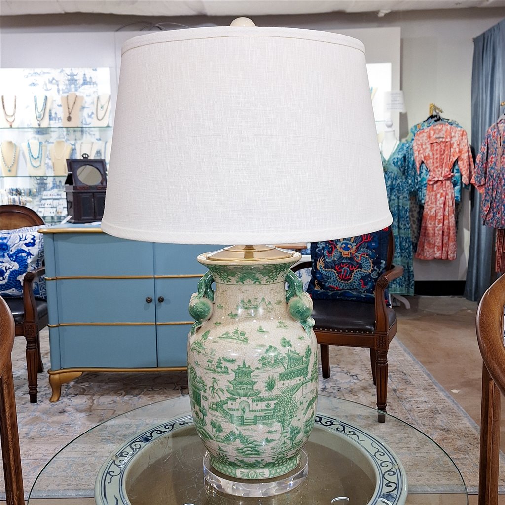 Illuminate your living room with the timeless elegance of the Mesa Green and White Porcelain Table Lamp. This contemporary piece features a natural crackle finish with brass accents, complemented by an acrylic base and lamp shade. Add a touch of classic sophistication to your home decor with this stunning lamp.