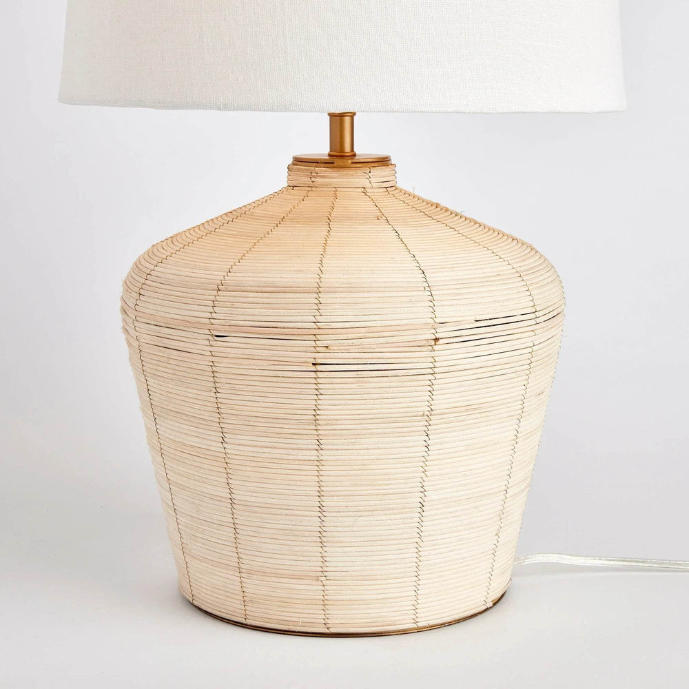 This mini lamp is crafted from natural cane rattan, showcasing individual color variations that add a one-of-a-kind touch. Designed for kitchen counters or compact workspaces, its petite shape and tailored shade make it a timeless piece. With its jute qualities, this lamp is the perfect addition to a neutral color scheme in your living room or dining room.
