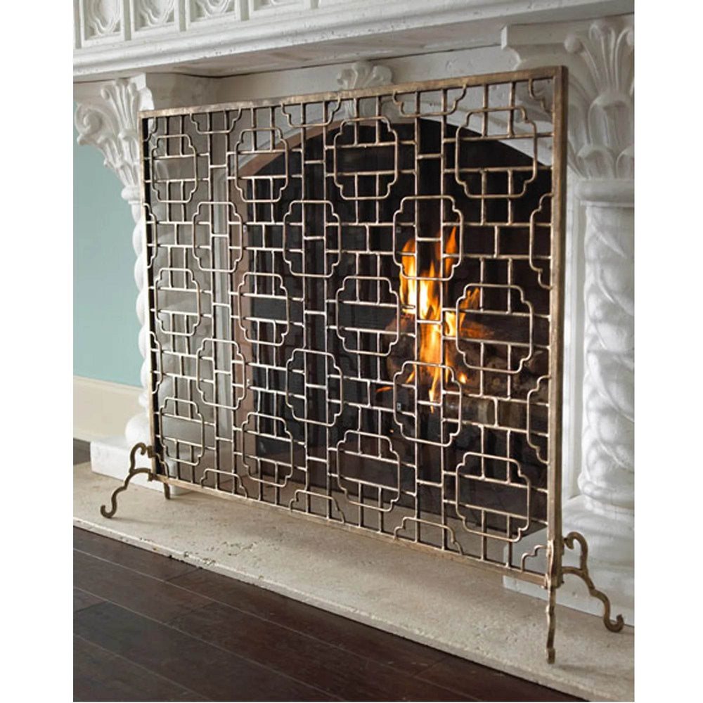 Side view of gold geometric fireplace screen with scroll feet and mesh detail, highlighting hand-finished texture and elegant symmetry.