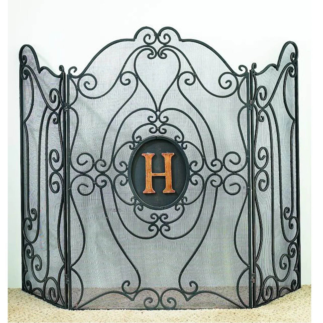 Custom 3-panel fireplace screen with ornate black wrought iron scrollwork and mesh backing, featuring a central oval monogrammed with the letter H.