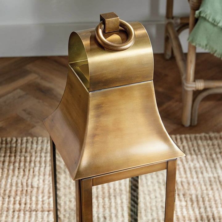 Close-up of tall antique brass lantern top with sculpted cap and oversized loop handle for decorative indoor styling – Transitional Classic Lantern