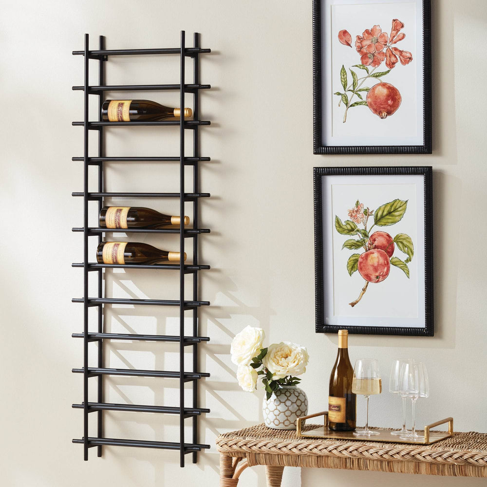Vertical black iron wall wine rack for 12 bottles, styled in dining room beside framed fruit prints, console, and wine glasses.