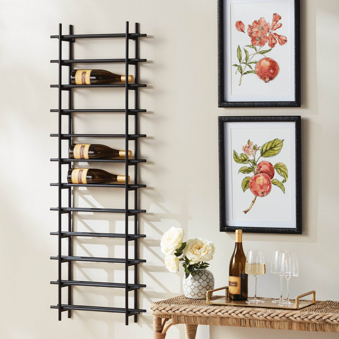 Vertical black iron wall wine rack for 12 bottles, styled in dining room beside framed fruit prints, console, and wine glasses.