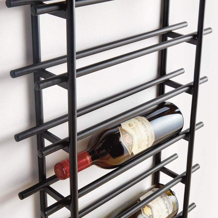 Detailed side view of black iron vertical wall wine rack showing wine bottles resting in sturdy round metal stock construction.