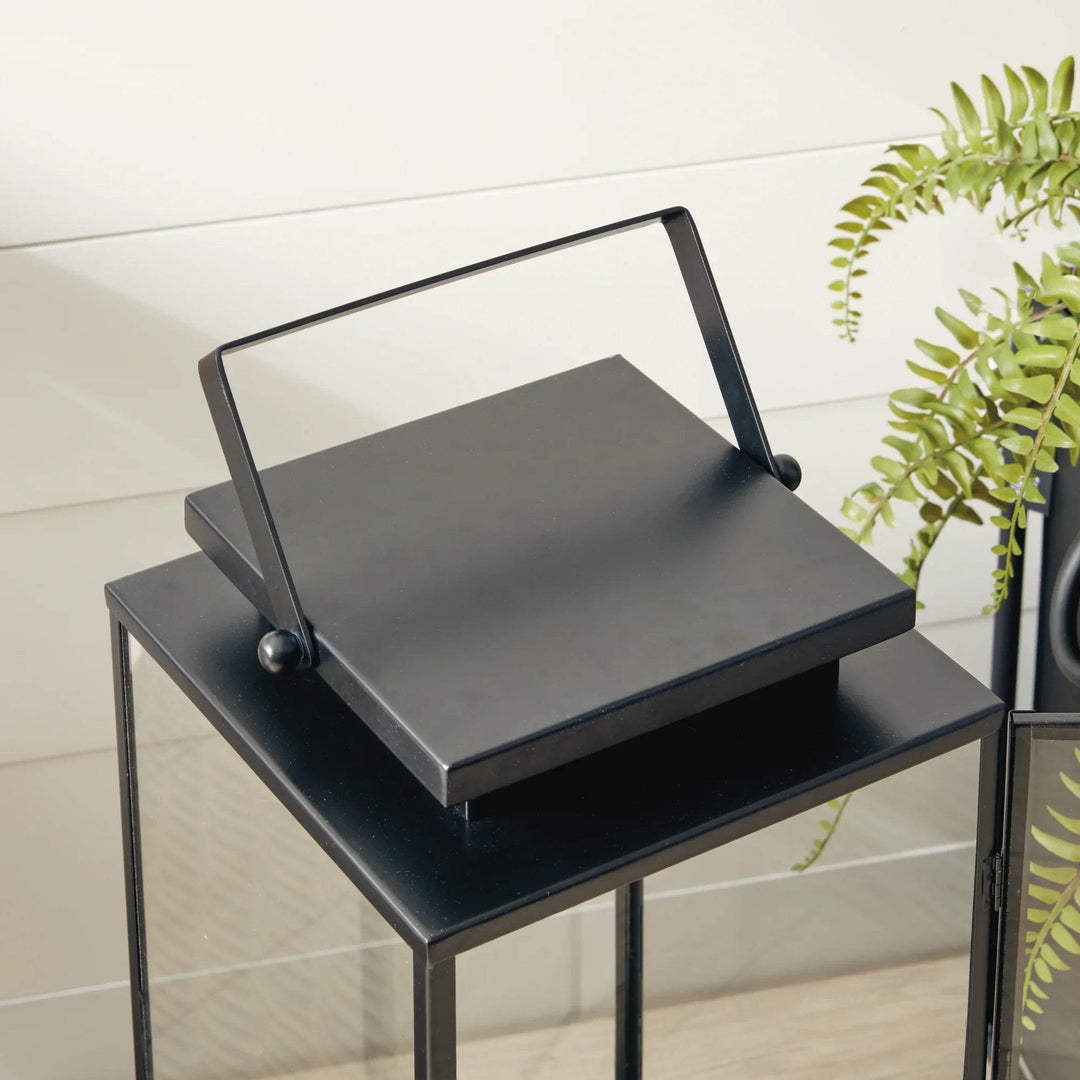 Close up of black stainless steel outdoor lantern handle and square top detail, transitional design with clean lines – Transitional