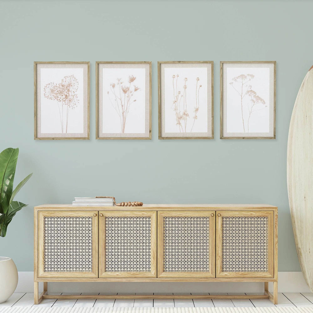 Framed farmhouse botanical prints styled above a console in a light entryway, showing grid-style layout and soft neutral tones.