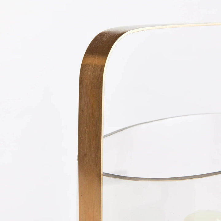 Close-up detail of matte brass handle and rim on large oval glass hurricane candle holder