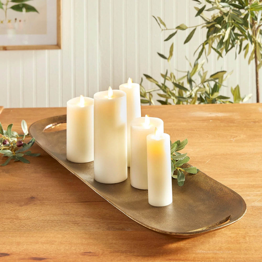 Brass metal tray with white candles and greenery styled on a dining table, highlighting warm finish – Transitional
