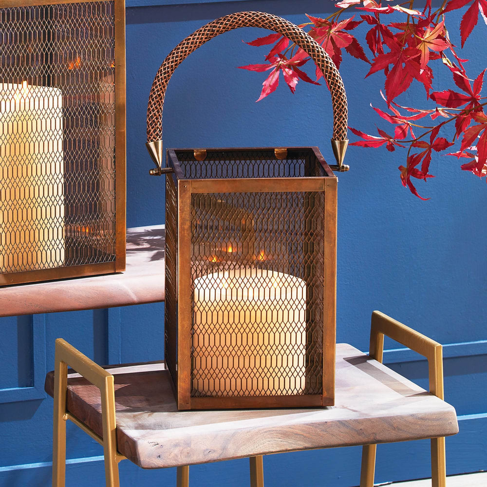 Bronze metal lantern with glass panels and rope handle displayed on a wood table with a lit candle, ideal for indoor styling – Industrial Modern.