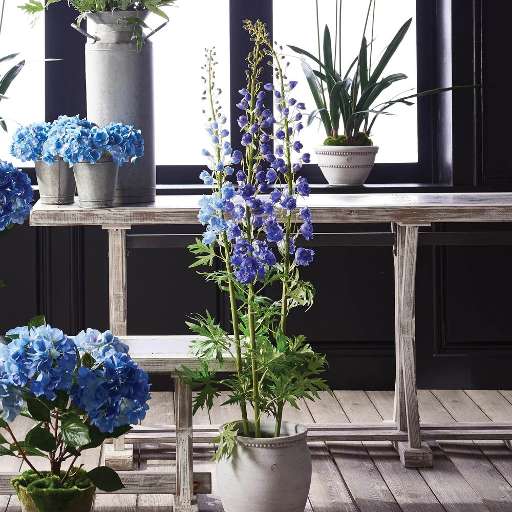 Faux delphinium stem styled in a white ceramic planter with blue florals on rustic wood bench – Modern Cottage