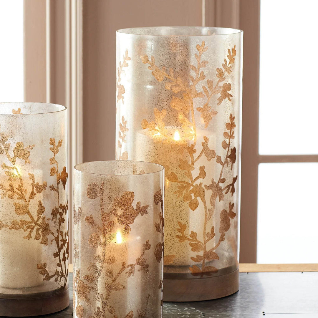 Glass hurricane with vine etching styled on console table with natural accents and decorative tray – Modern Natural style