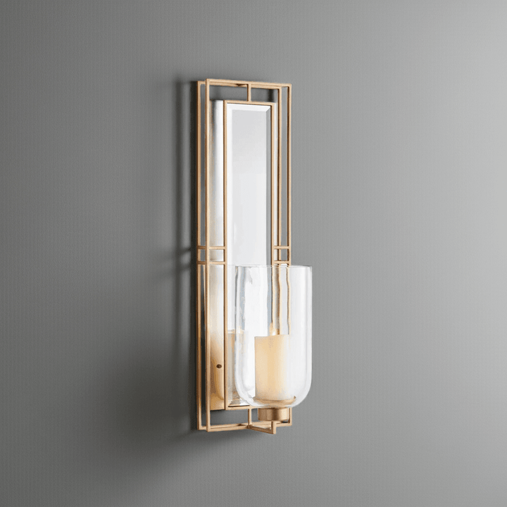 Champagne gold wall sconce with mirrored back and glass hurricane, 28 inches tall, mounted on wall with LED candle – Transitional décor.