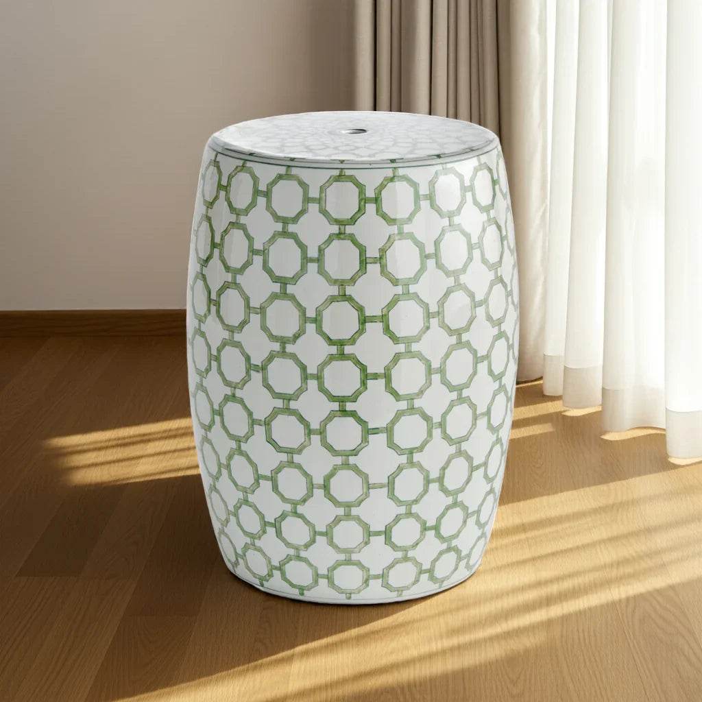 Green and white porcelain stool styled beside window in bedroom with wood floor and natural light.