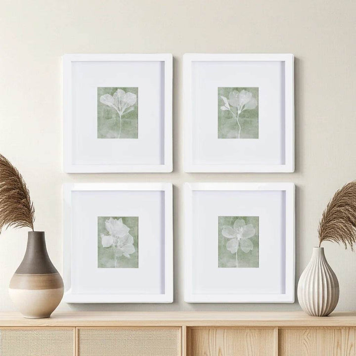 Modern floral art prints arranged in a minimalist space with light wood shelf and dried botanicals