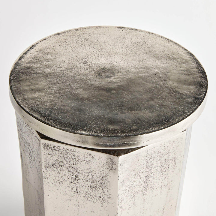 Top-down view of brushed silver accent stool with lightly textured circular surface