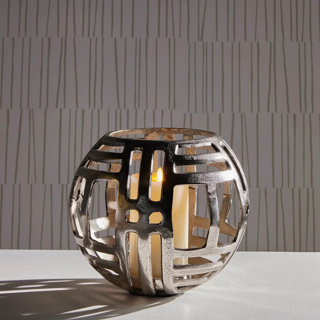 Large modern industrial silver hurricane candle holder with cut-out design, styled with LED candle for console or table decor.
