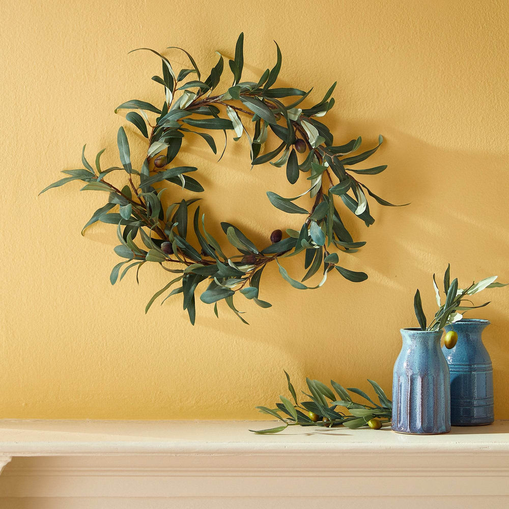 16 inch faux olive wreath styled on wall with vases, featuring soft green foliage and Mediterranean-inspired design – Mediterranean Classic.
