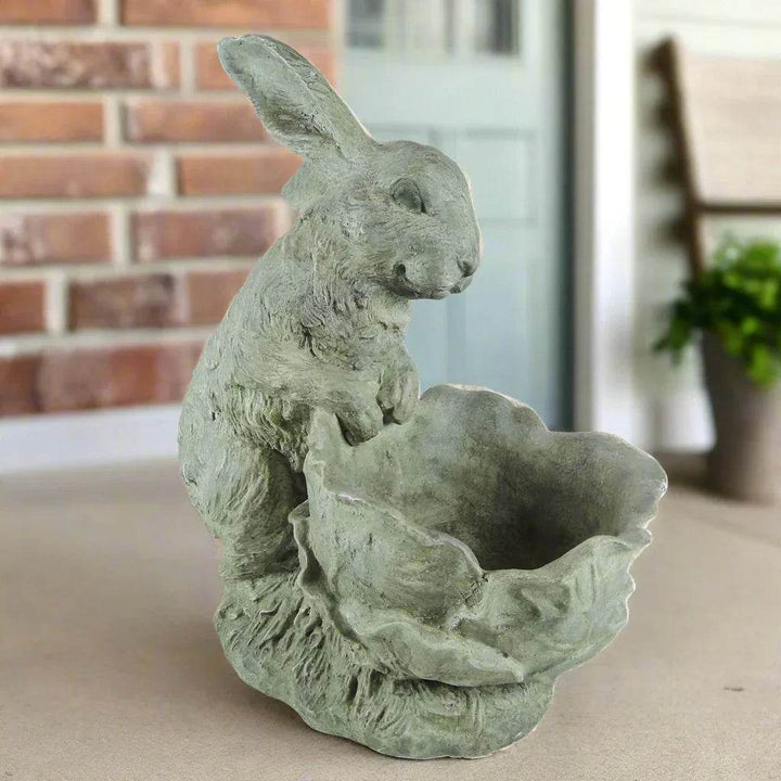 Bunny rabbit cement planter placed on a front porch with soft neutral tones and brick background