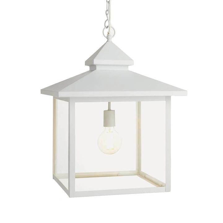 Refined farmhouse white pendant light with barn-style roofline and glass panels, front view.