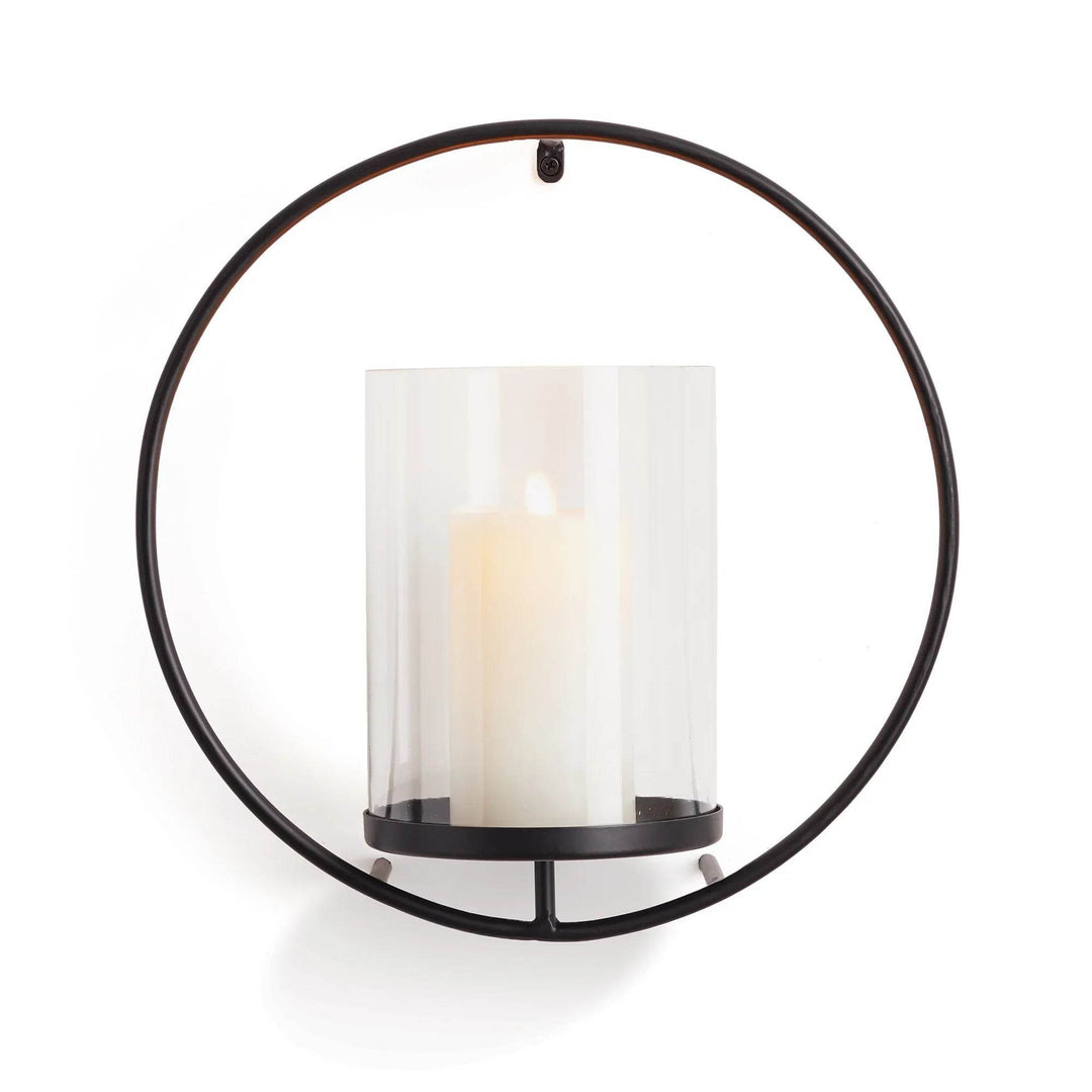 Front view of round black metal wall candleholder with clear glass hurricane and LED pillar candle – Industrial Modern.