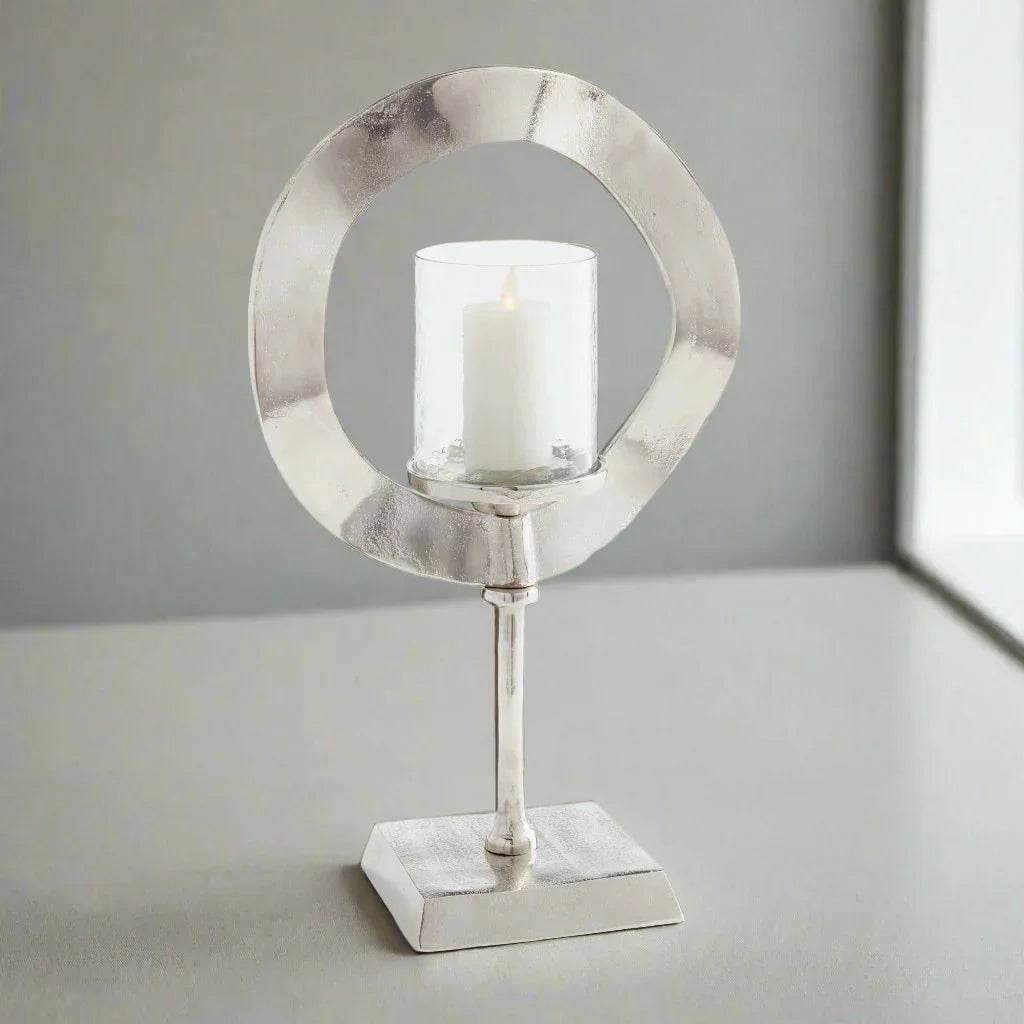 Silver candle stand with glass hurricane and LED candle styled on shelf, modern sculptural accent for minimalist glam home decor – Minimalist Glam.
