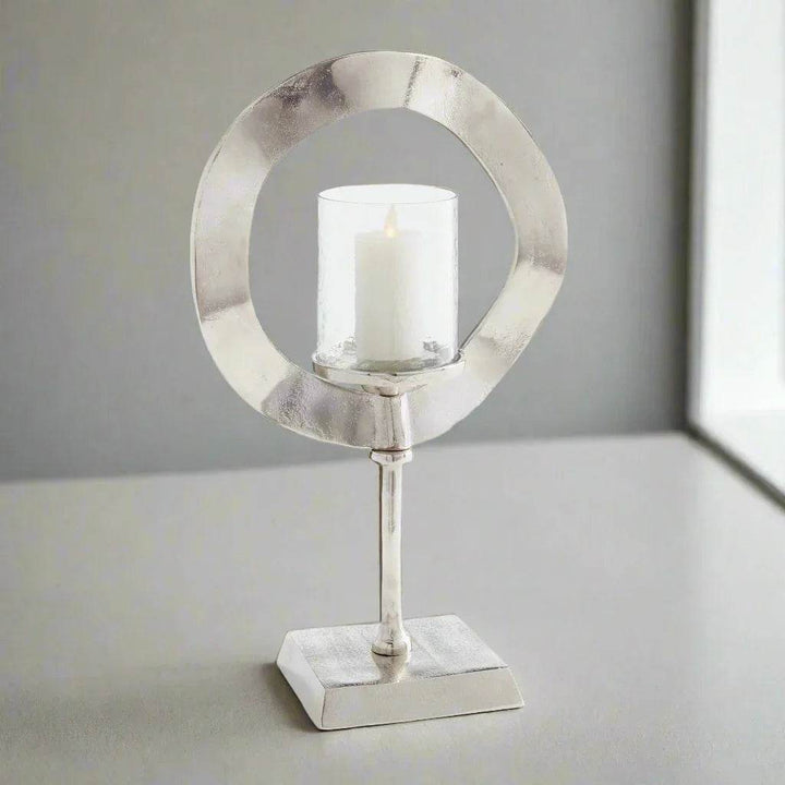 Silver candle stand with glass hurricane and LED candle styled on shelf, modern sculptural accent for minimalist glam home decor – Minimalist Glam.
