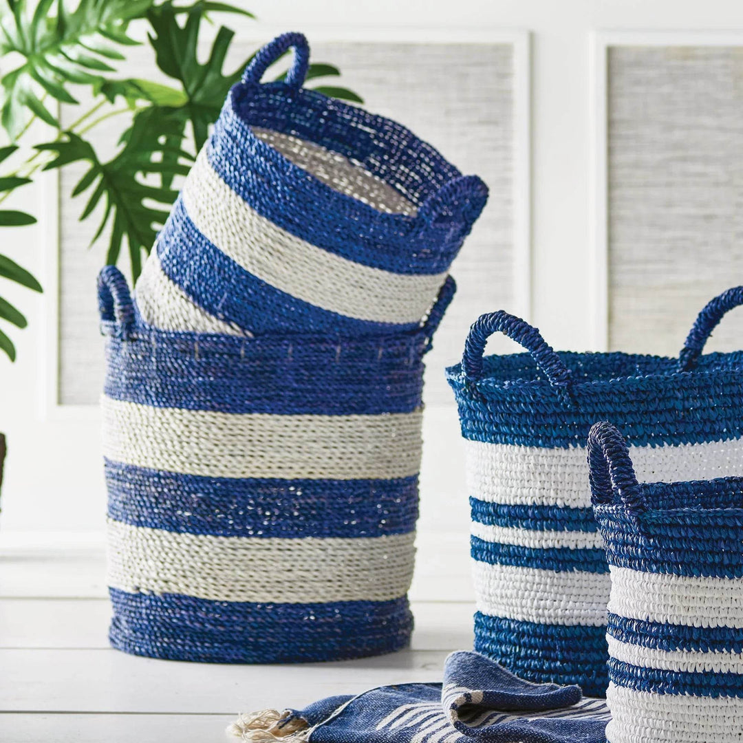 Tall striped baskets in blue and white woven seagrass, styled with tropical greenery for indoor use.