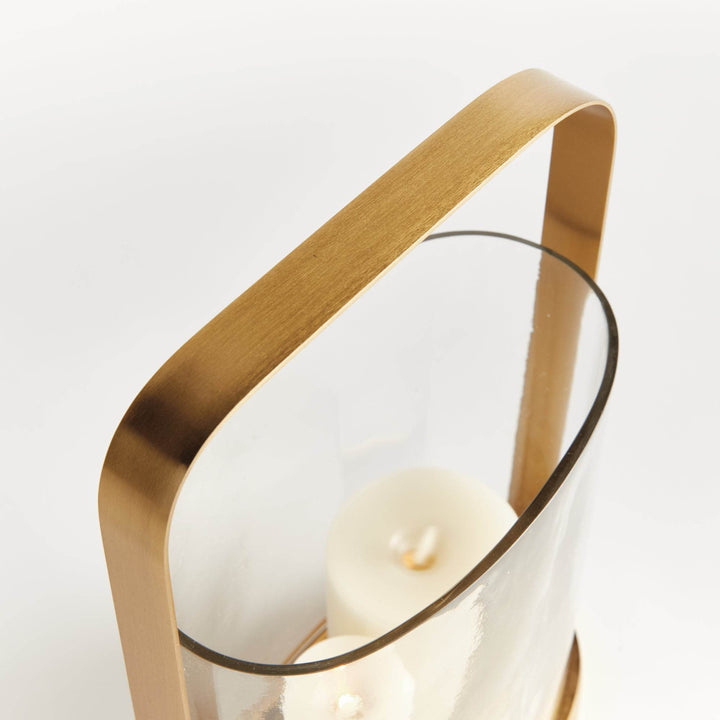 Detail of the handle and rim on the small transitional brass and glass hurricane candle holder in warm matte brass.