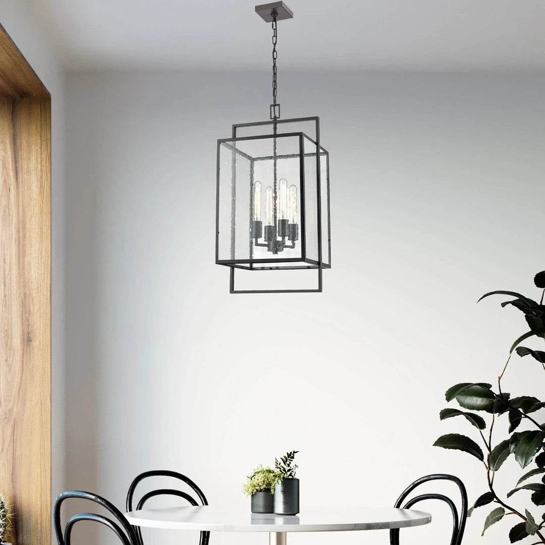 Bronze Urban Loft pendant light hanging above a modern dining table, styled with curved black chairs and soft natural lighting.