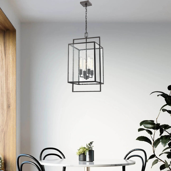 Bronze Urban Loft pendant light hanging above a modern dining table, styled with curved black chairs and soft natural lighting.