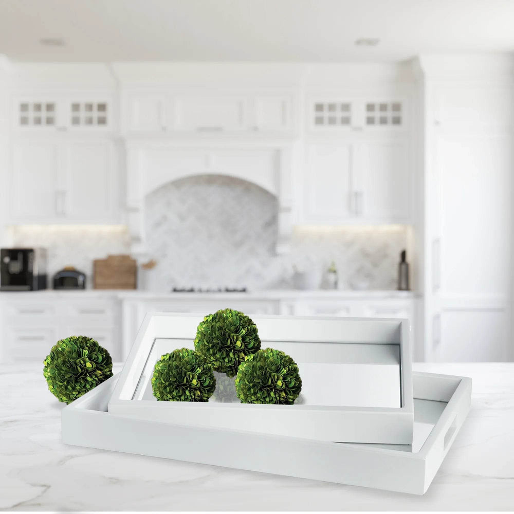 White mirrored trays styled on marble counter in bright kitchen with green decor accents – Modern Coastal.