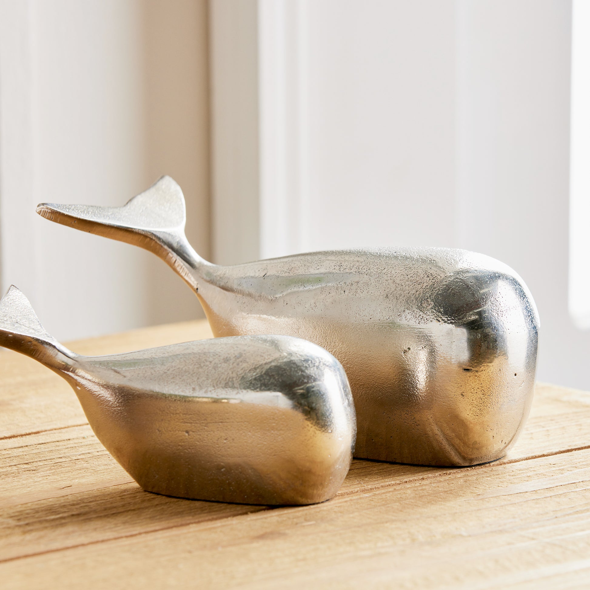 Expertly crafted from solid aluminum, these modern whale sculptures exude charm and coastal vibes. While smaller in size, they make a great shelf accent and add character to any space. Experience the durability and sleek design of these refined sculptures.