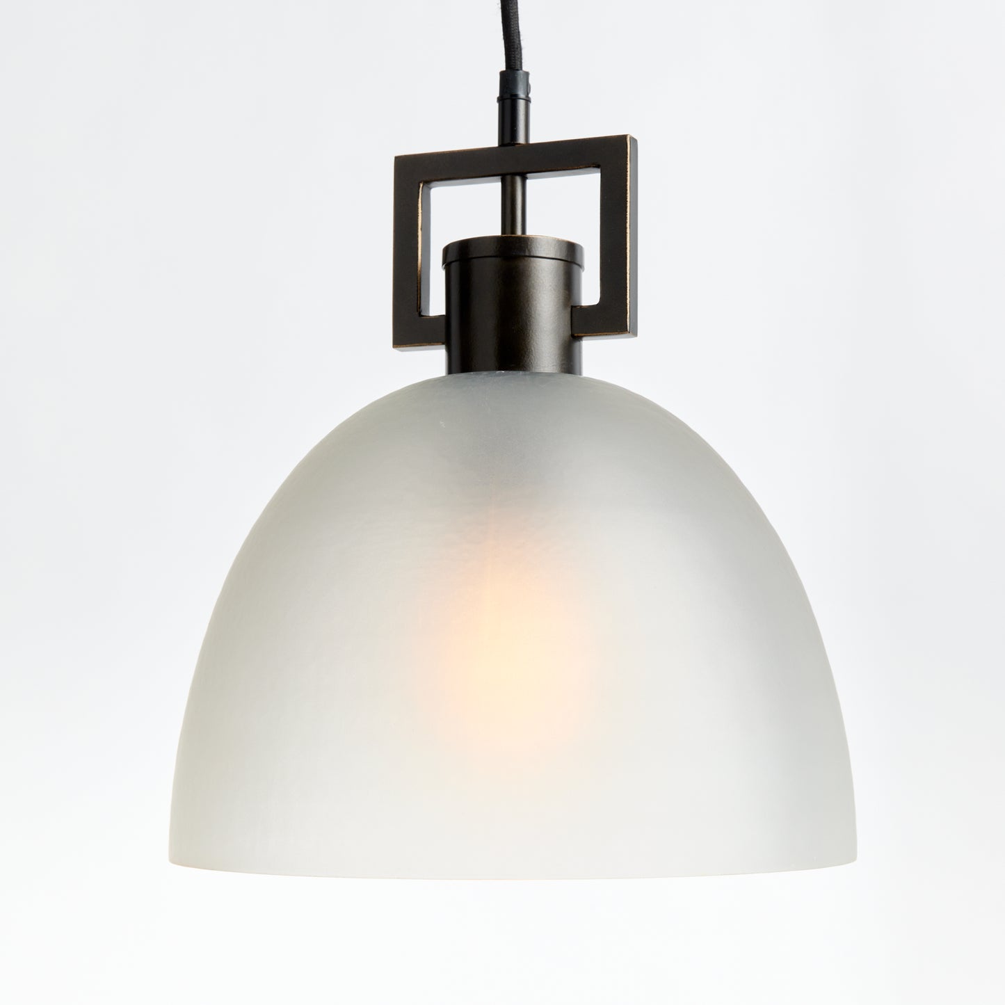 This antique bronze pendant light boasts a timeless design, with its warm finish and opaque matte glass providing a diffused light. Ideal for adding a touch of classic elegance, it can be hung over an island, in an entryway or foyer.