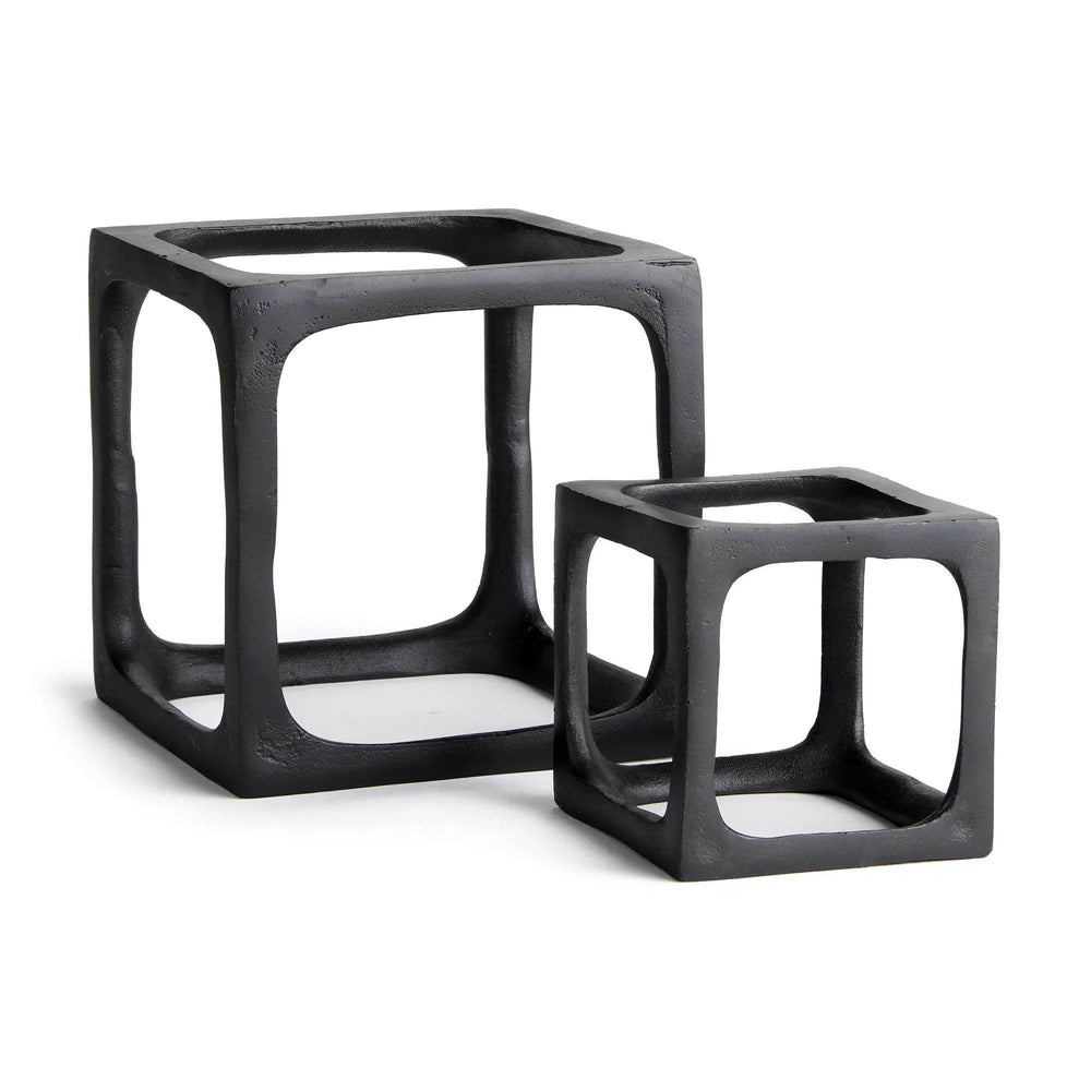 Two black cube-shaped sculptures on a white background