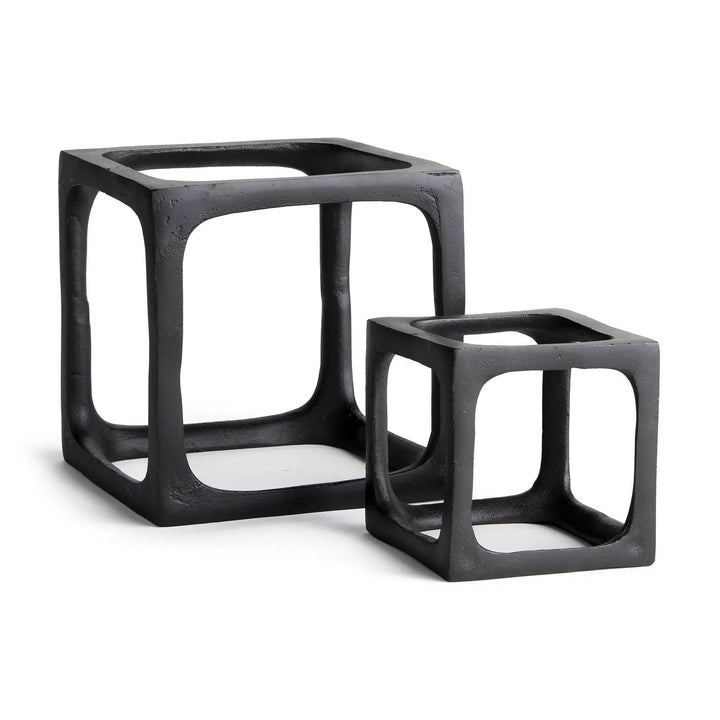 Two black cube-shaped sculptures on a white background