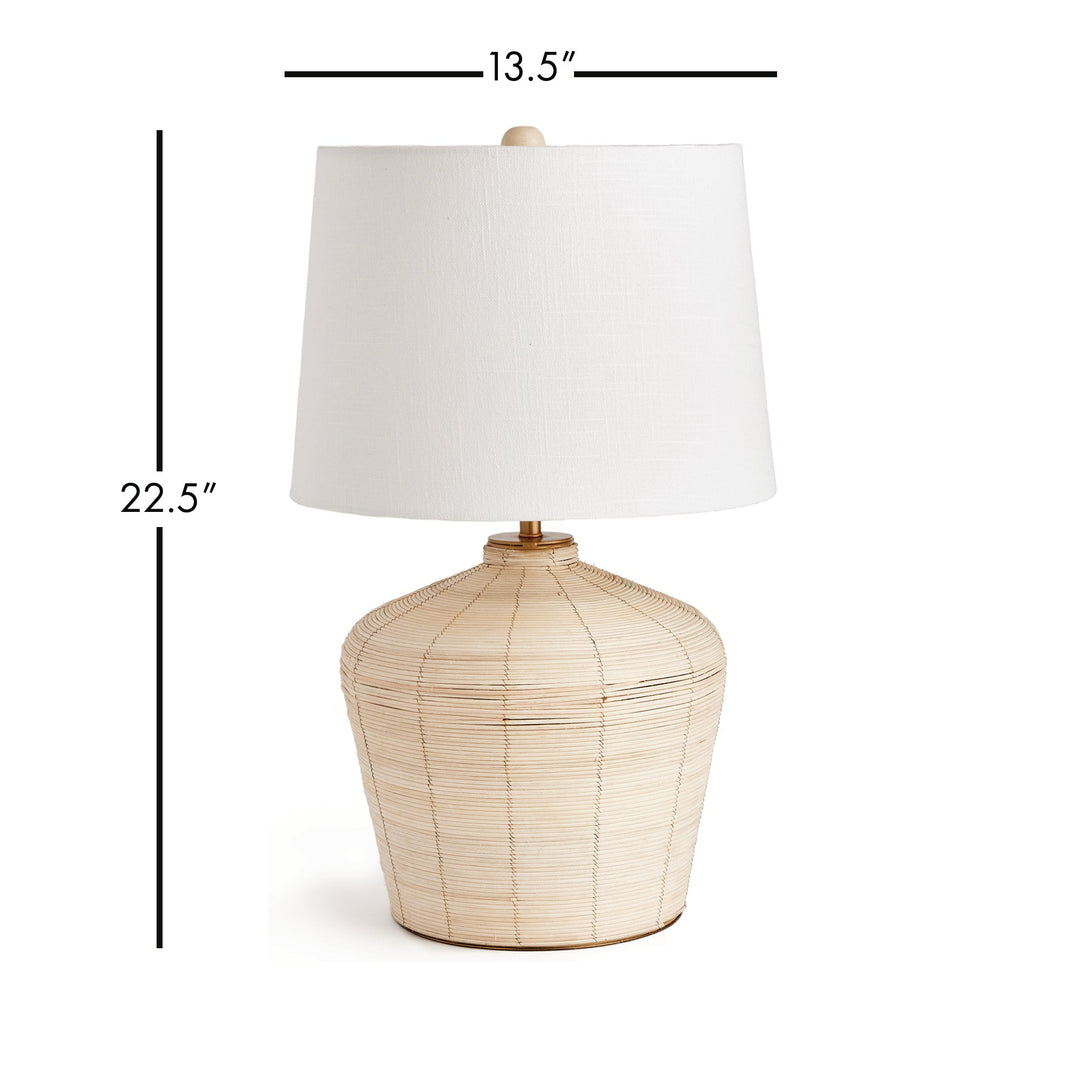 This mini lamp is crafted from natural cane rattan, showcasing individual color variations that add a one-of-a-kind touch. Designed for kitchen counters or compact workspaces, its petite shape and tailored shade make it a timeless piece. With its jute qualities, this lamp is the perfect addition to a neutral color scheme in your living room or dining room.