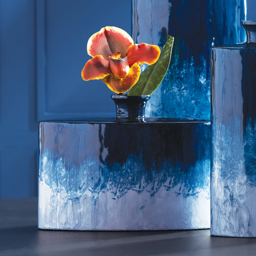 Crafted with expertise, the Azul Decorative Flask Vase showcases an artful ombre design in deep blue hues, inspired by the natural world. The lightweight enameled iron material adds a touch of simple elegance to this hand-painted beauty.