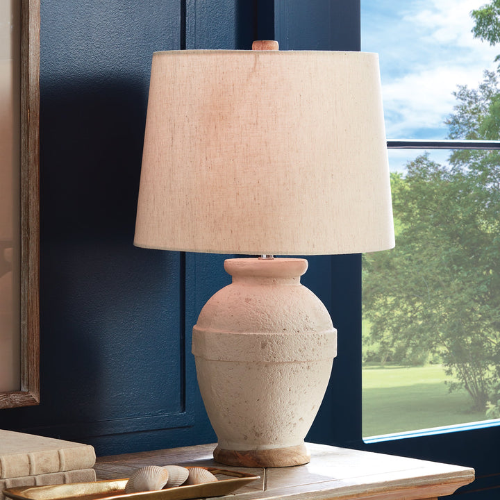 This table lamp features a composite base made of natural Eco mix, incorporating hardening agents for long-lasting durability. The warm white finish adds a subtle texture, showcasing the unique composition of the material. Topped with a linen tapered shade and banded silhouette, this petite lamp is perfect for bedside tables or desks. Designed with sustainability in mind, it utilizes an Eco mix made from natural materials, combining durability with eco-friendliness.