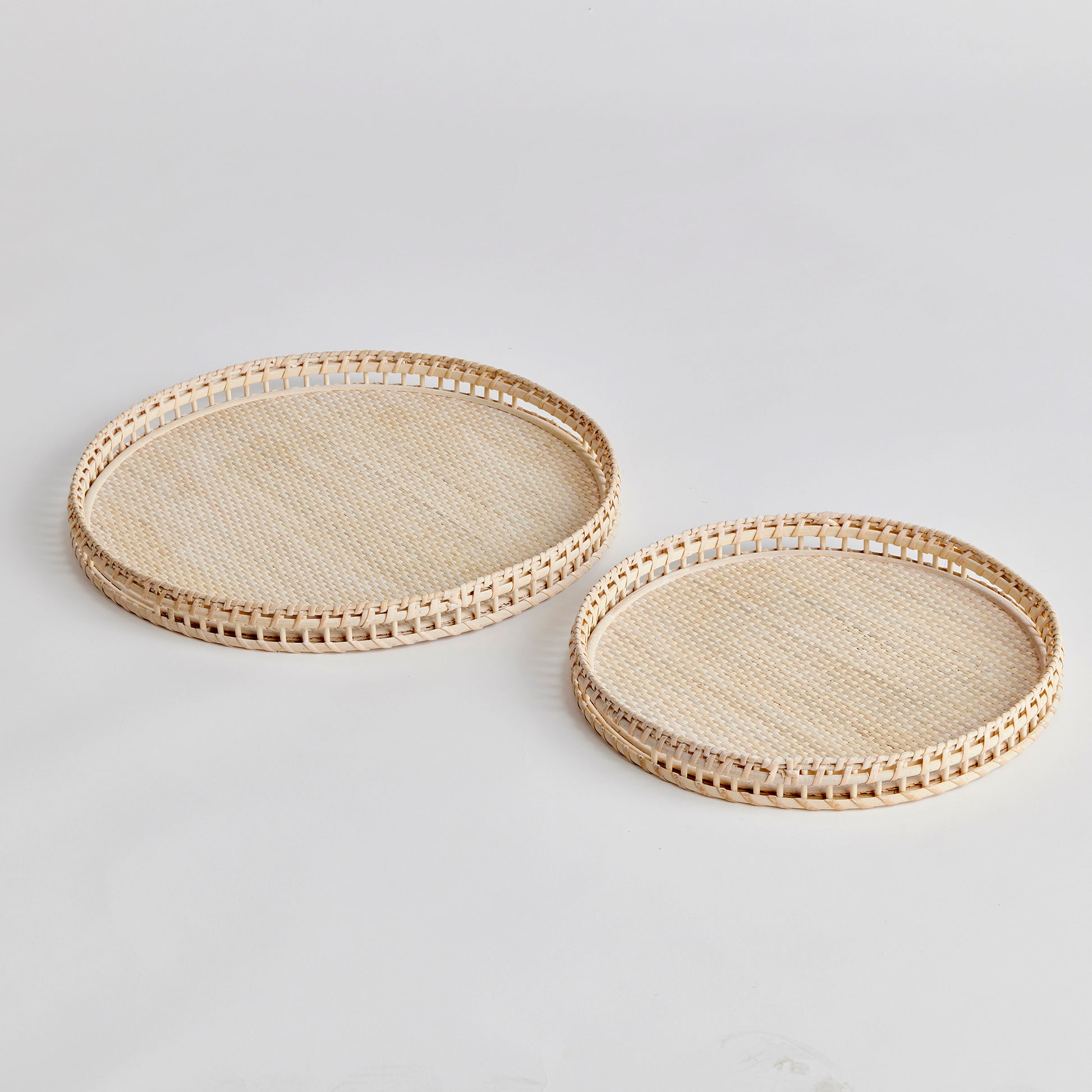 Crafted from woven rattan and coated with a fresh whitewash finish, these coastal-inspired trays add a touch of charm to any space. Use them on your coffee table or ottoman as a stylish base for creating beautiful vignettes. Enhance your home decor with Barri Coastal Decorative Trays Set of 2.