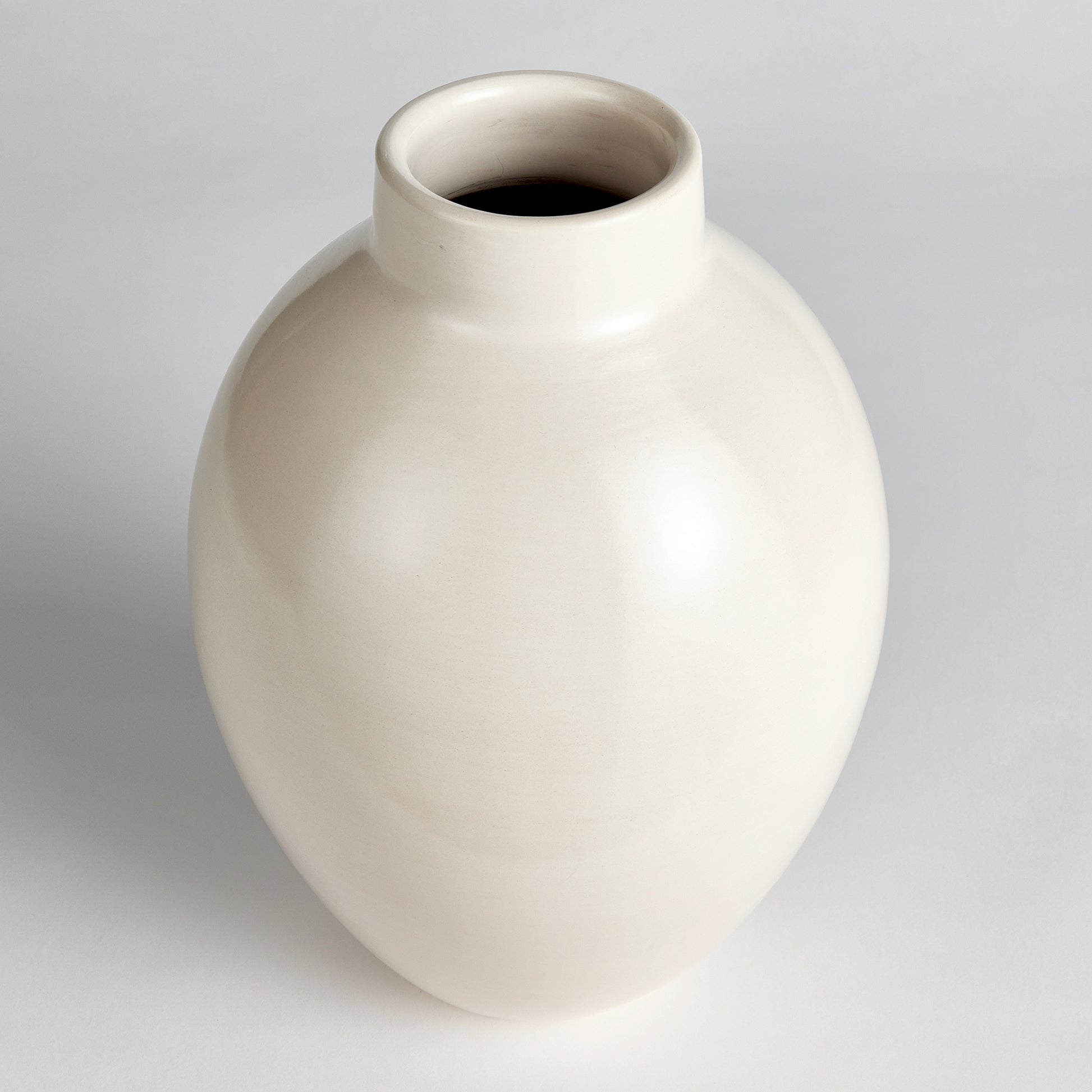 This exquisite ceramic vase is artfully crafted using traditional techniques from Chulucanas, Peru. The warm climate and ancient Incan methods contribute to its exceptional quality and the artisan's touch adds an authentic element. Through a wire pad buffing technique, a subtle texture is created, and a unique ecru pigment is carefully applied during the firing process. This results in a durable, long-lasting piece that brings a touch of warmth and charm to any space.