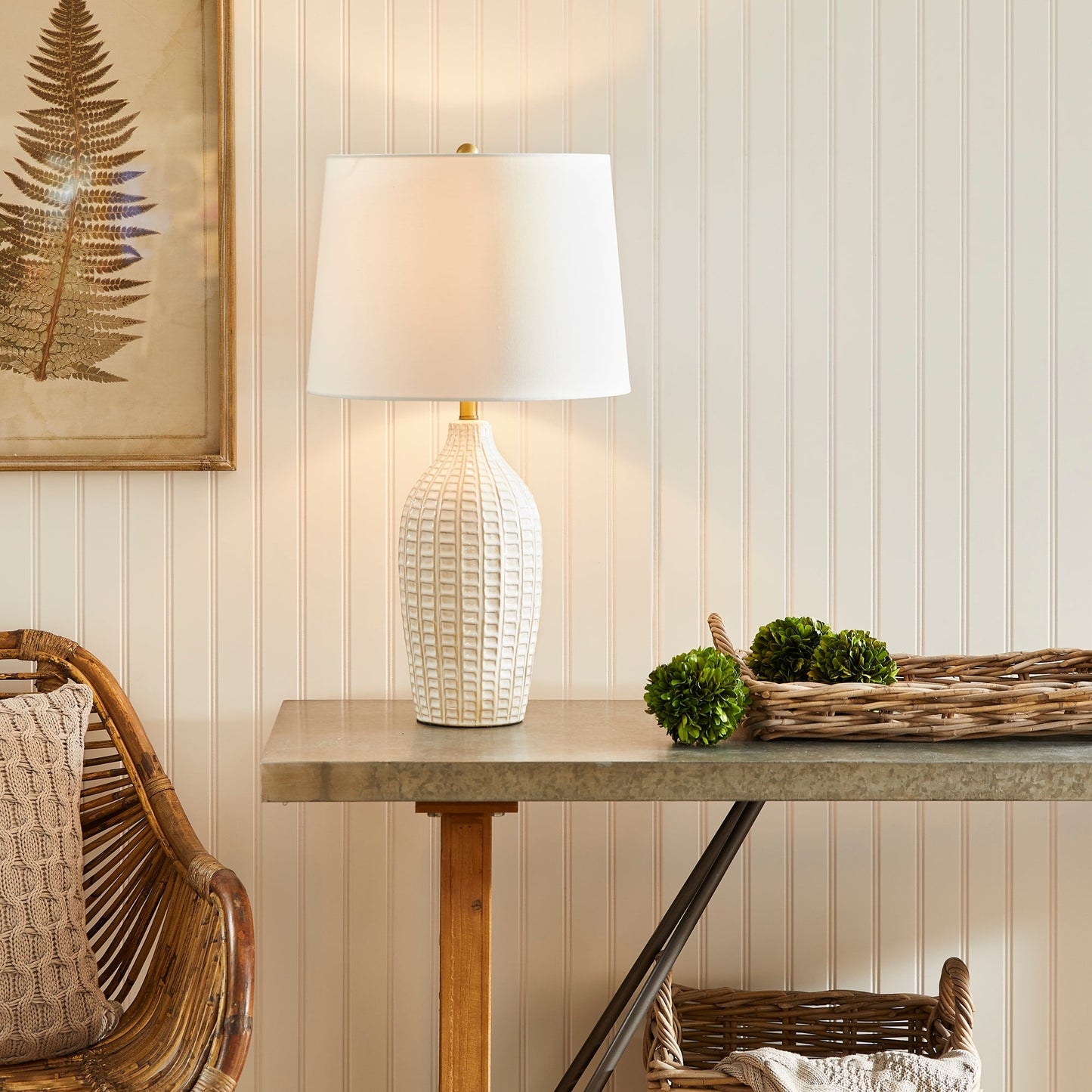 With a pressed pattern on the ceramic body, the Nadia Lamp is a work of art. Topped off with a generously scaled fabric shade, it is sure to enhance any space. intricate details, bold, finial, classic white, metal accents This ceramic lamp boasts an eye-catching pressed pattern and an elegantly designed fabric shade, making it an artistic addition to any room. With intricate details, a bold finial, and classic white coloring with metal accents, it offers both style and subtlety.