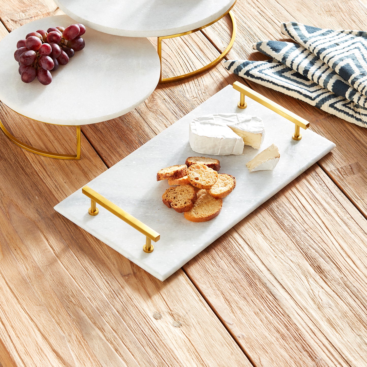 This Marble Serving Tray features a timeless pairing of marble and brass, making it the perfect way to present your favorite cheese and cracker platters. Its versatile design is suitable for coastal, traditional, and transitional settings, elevating your hosting game with a touch of sophistication. Whether you're serving a decadent cheese platter or a simple cracker spread, this tray is sure to impress, adding an elegant touch to any occasion.