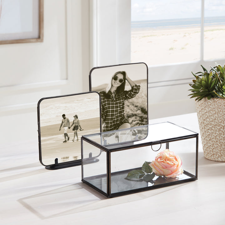 The Arwen Rectangular Black Display Box is the ideal solution for elegantly displaying and preserving your valuable keepsakes. Made of glass and brass with a delicate loop handle, this carefully crafted box ensures your mementos remain in pristine condition while adding a touch of style to your décor. By investing in this display box, you can showcase your most treasured items with ease and sophistication.