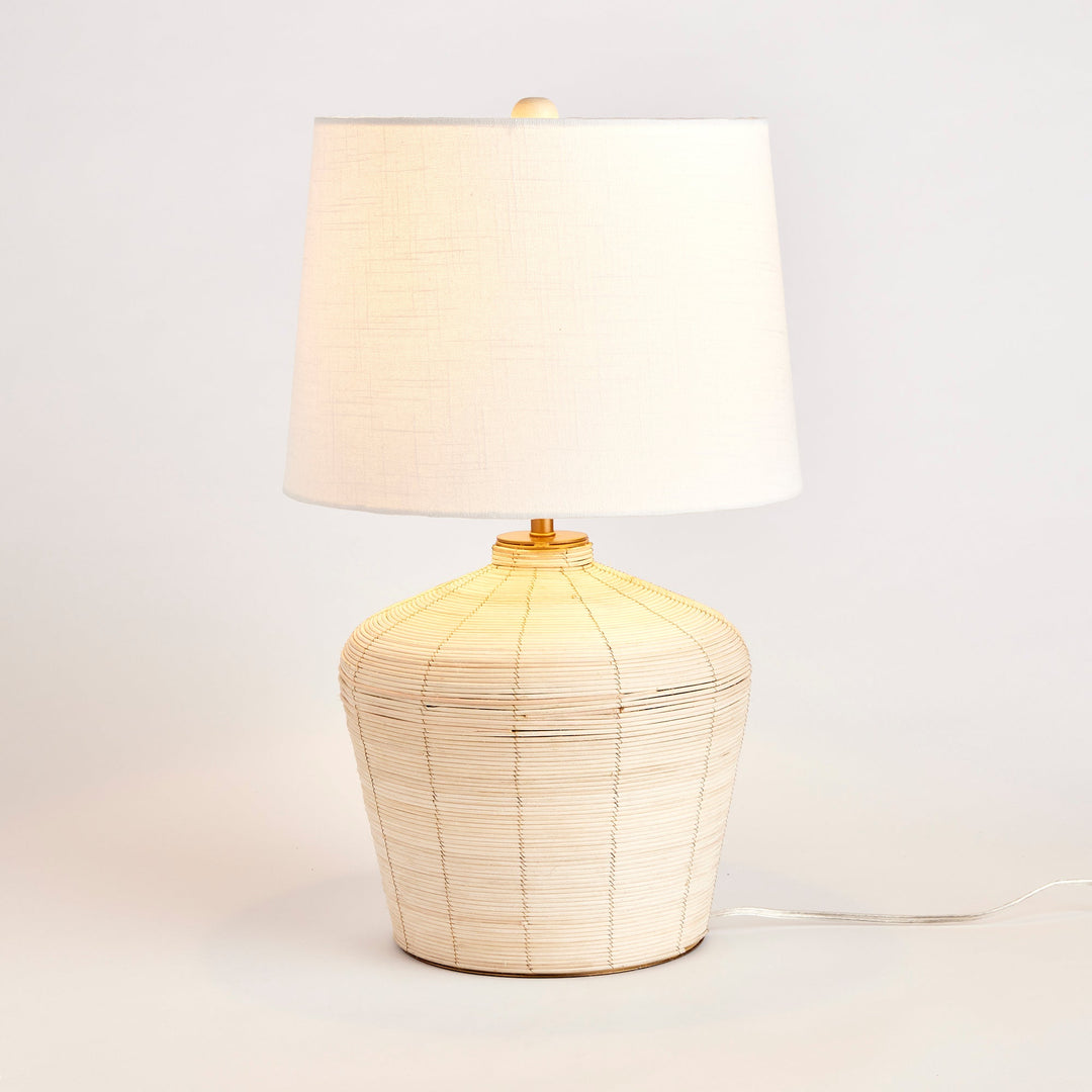 This mini lamp is crafted from natural cane rattan, showcasing individual color variations that add a one-of-a-kind touch. Designed for kitchen counters or compact workspaces, its petite shape and tailored shade make it a timeless piece. With its jute qualities, this lamp is the perfect addition to a neutral color scheme in your living room or dining room.