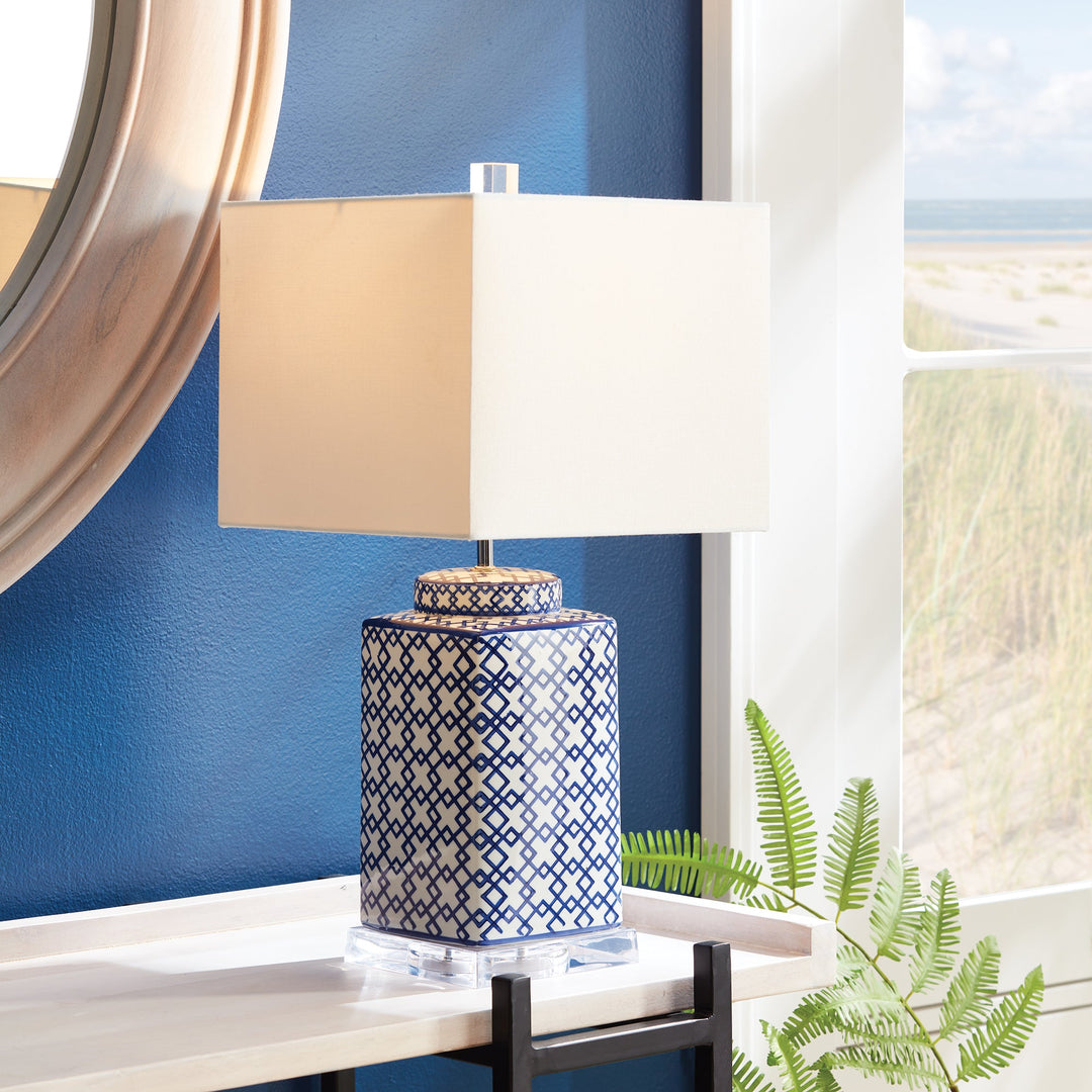 This blue and white table lamp features a striking square shape and bold pattern, making it an elegant choice for any room. Whether placed on a side table, console, or shelf, it is sure to brighten up the space. With an acrylic stand, ceramic base, and linen shade, this lamp is the perfect blend of style and functionality.