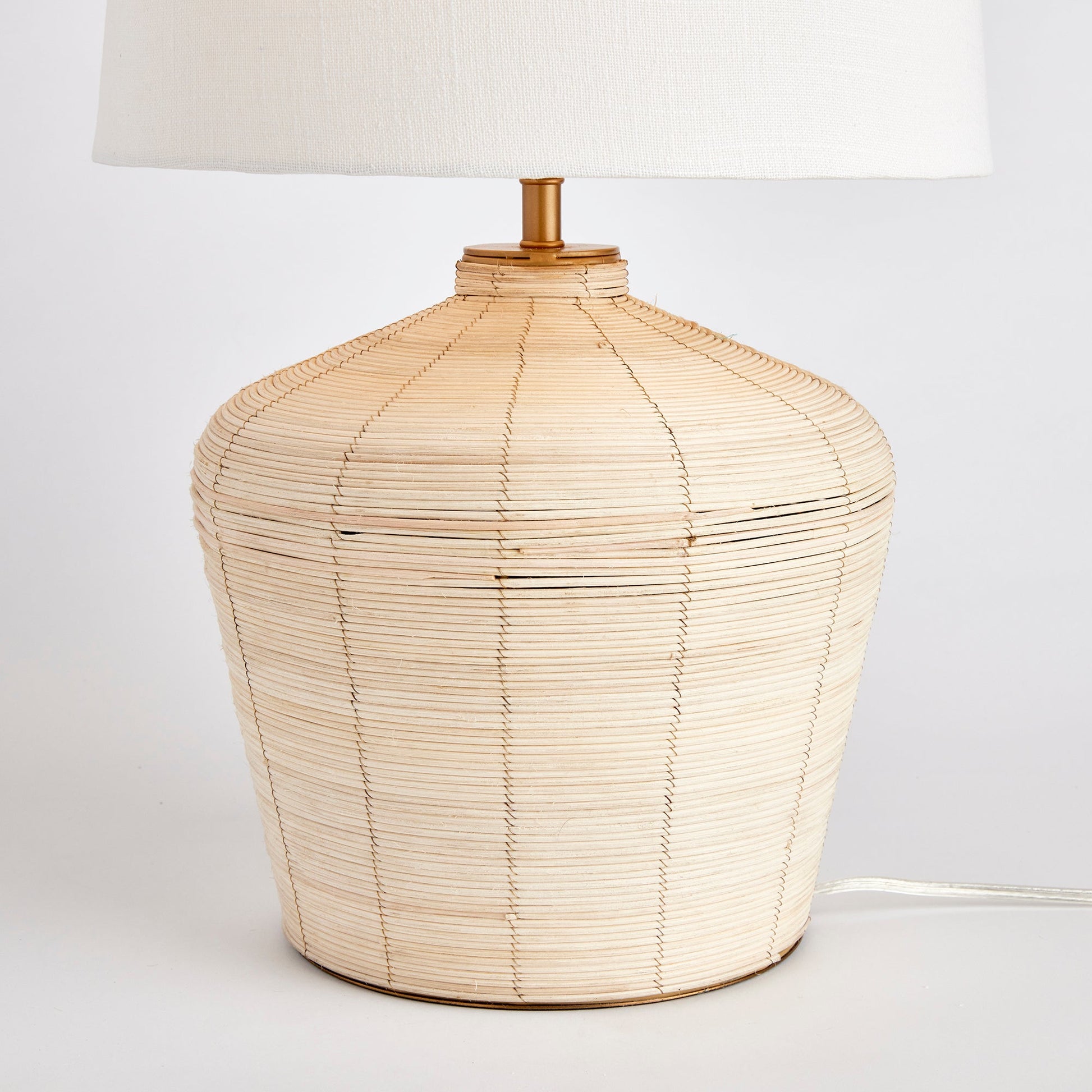 Expertly handcrafted with a distinctive whitewash cane rattan weave, the Maye Tapered Rattan Table Lamp is truly one-of-a-kind. Its wide cylindrical shade makes it a versatile and charming accent for any bedroom, living room, or study. With unique color variations achieved through the weaving process, this lamp adds a touch of elegance to any room. Complete with a matching finial, it is the perfect addition to your home decor.