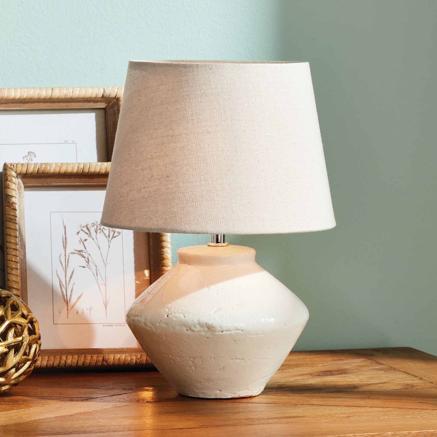 Expertly crafted from high-quality ceramic, this mini table lamp is the perfect addition to any transitional setting. Its petite base and textured cream/beige shade make it a versatile piece, ideal for accentuating kitchen counters, bookshelves, or desks. Featuring an in-line switch and a beige linen shade, this lamp combines style and functionality seamlessly.