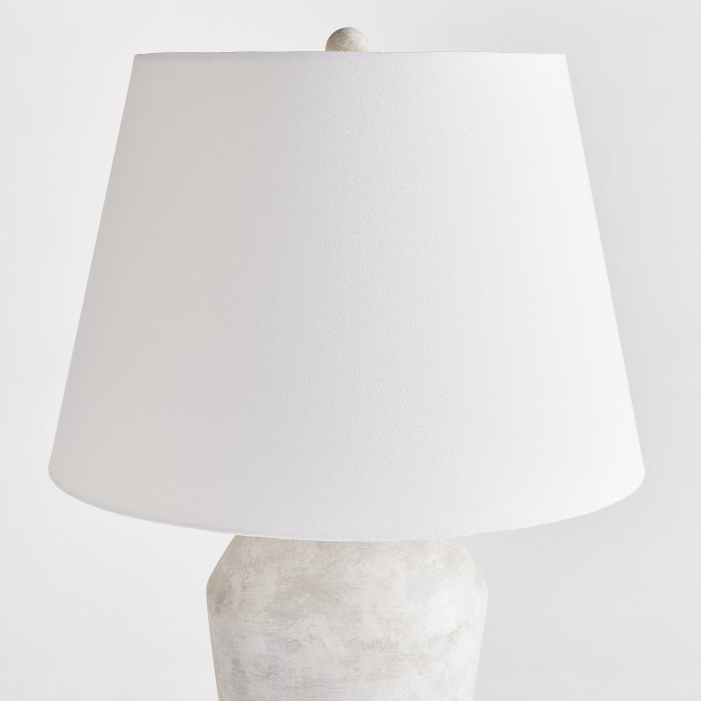 Expertly crafted from a centuries old wooden mold, this warm stone finish table lamp boasts a classic silhouette that will elevate any room. The tapered fabric shade adds a touch of elegance and creates a dynamic, storied lighting experience for any space in your home. Designed for family rooms, studies, and bedrooms, this lamp perfectly balances style and functionality