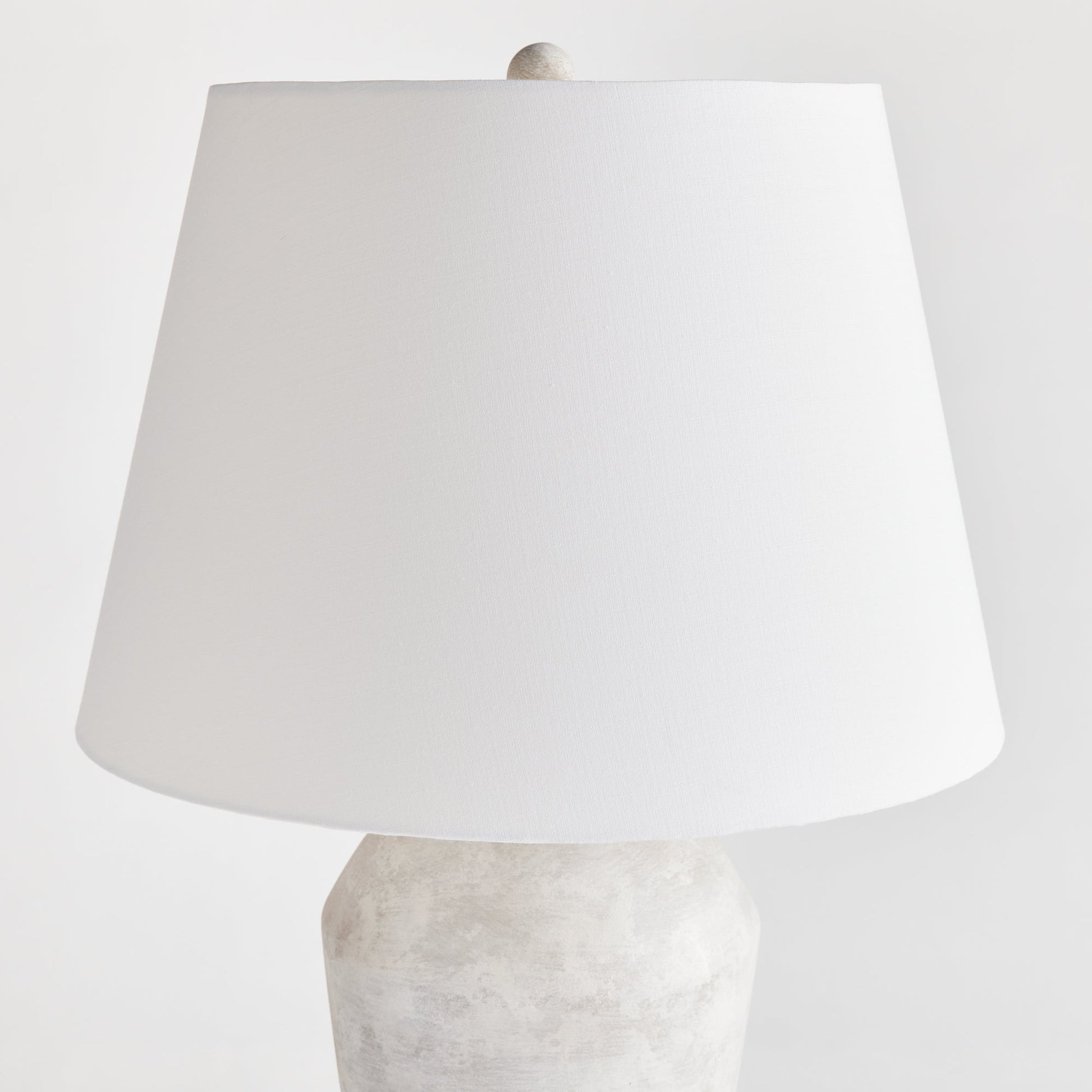 Expertly crafted from a centuries old wooden mold, this warm stone finish table lamp boasts a classic silhouette that will elevate any room. The tapered fabric shade adds a touch of elegance and creates a dynamic, storied lighting experience for any space in your home. Designed for family rooms, studies, and bedrooms, this lamp perfectly balances style and functionality