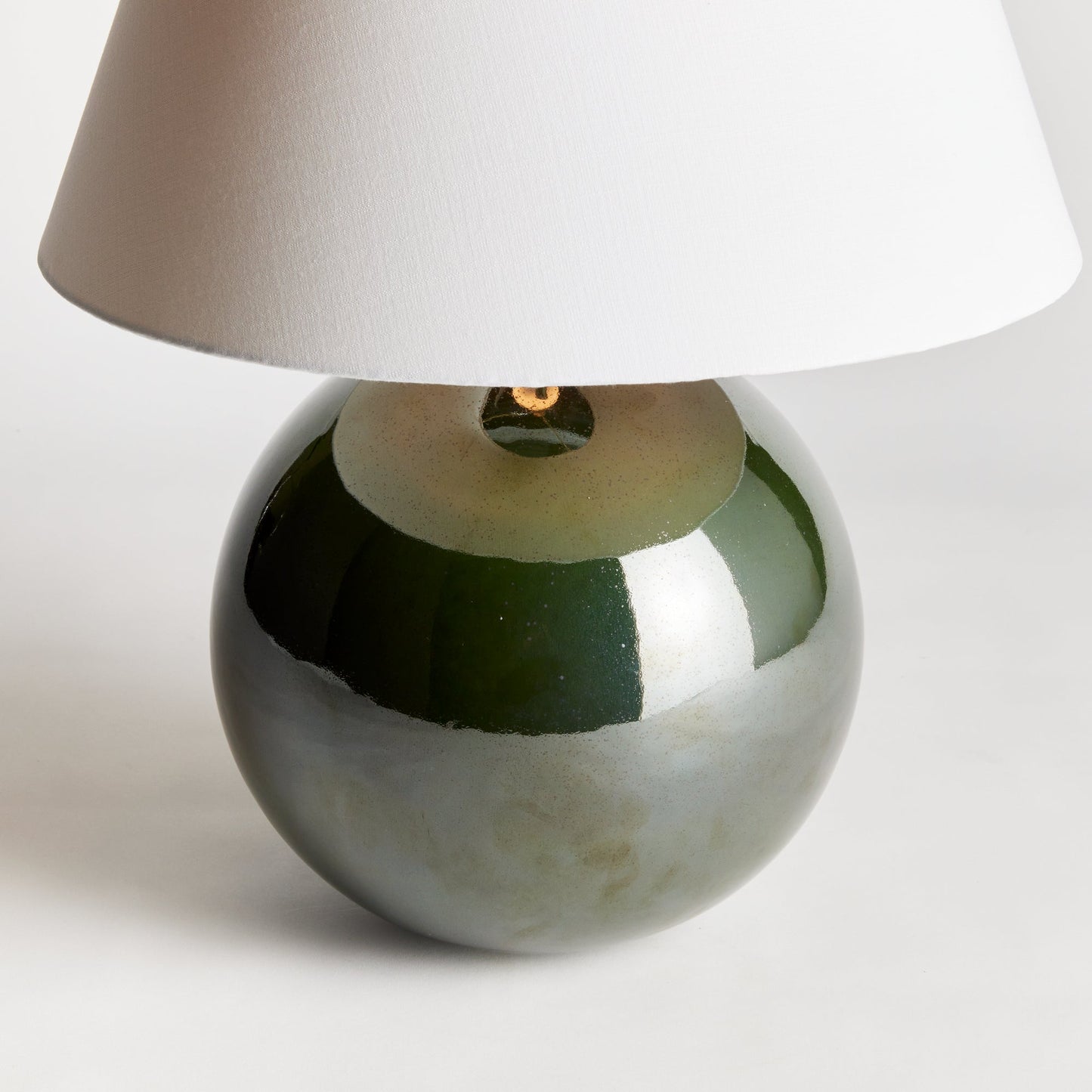 With a perfectly rounded ceramic body and a rich green high gloss glaze, this lamp adds a pop of color to any setting. Topped off with a bright white tapered shade, it makes a lovely accent for bedside table, side table or desk. Expertly crafted with a perfectly rounded ceramic body and a rich green high gloss glaze, the Bellamy Green Table Lamp is a stunning addition to any room